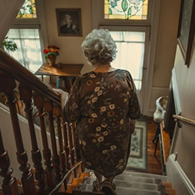 elderly lady climbing down a flight of stairs