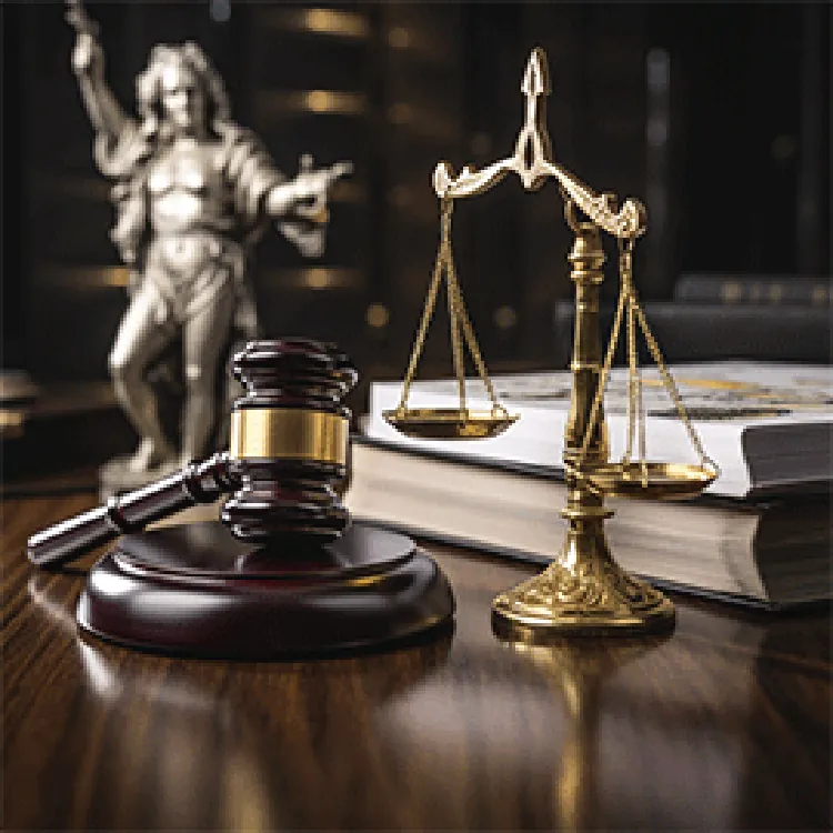 gavel, scales of justice, books, and a small statue on table