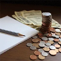 dollar bills, stack of coins, notepad, and pencil on table