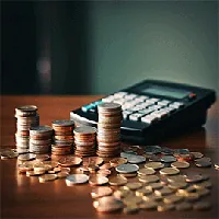 calculator, stack of coins and loose coins placed on a table