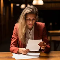 a woman reading a denial letter