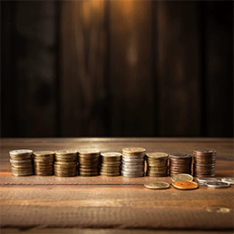 Stack of coins lined up on top of a wood table