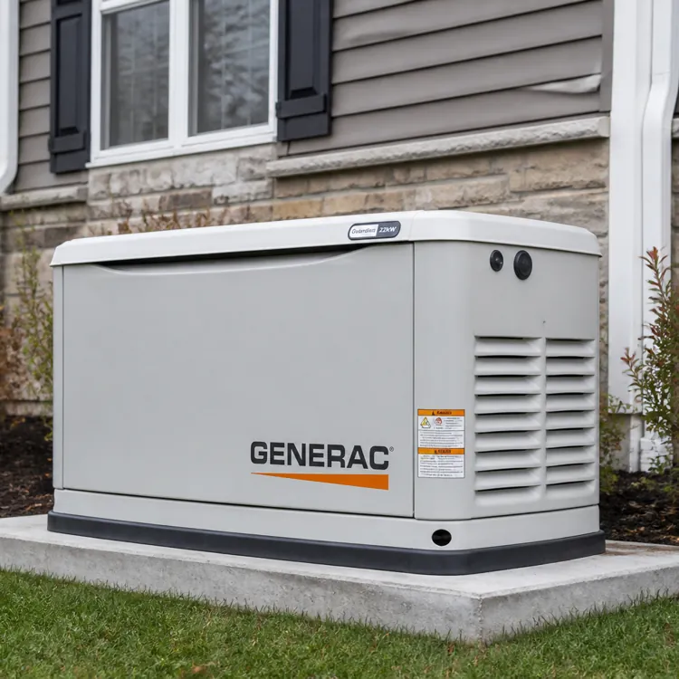 A standby generator unit installed on a concrete pad outside a house near shrubs and a window
