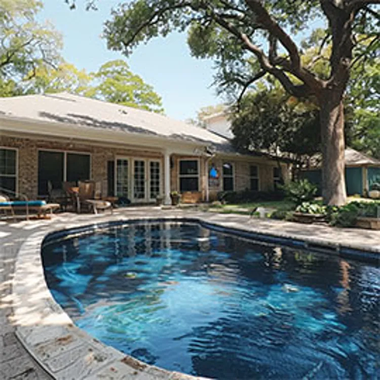 large pool in a home yard with lounge chairs beside it