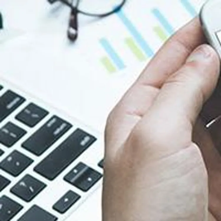 man holding phone showing credit score meter