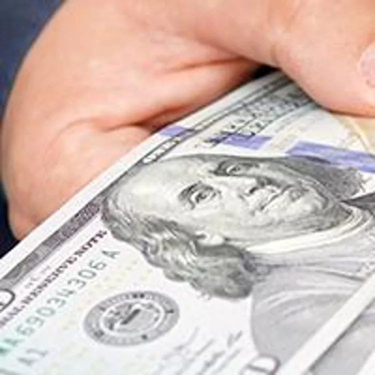 man holding several hundred dollar bills