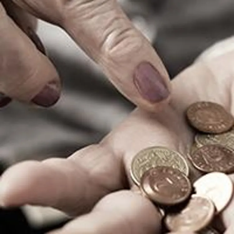 older woman counting coins in her hand