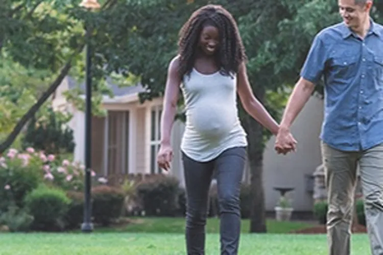 expecting couple walking dog