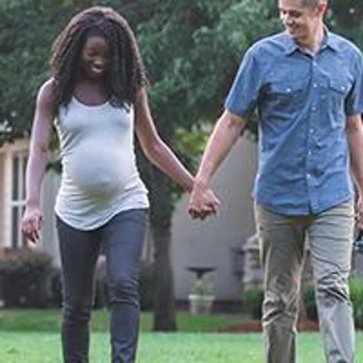 expecting couple walking dog