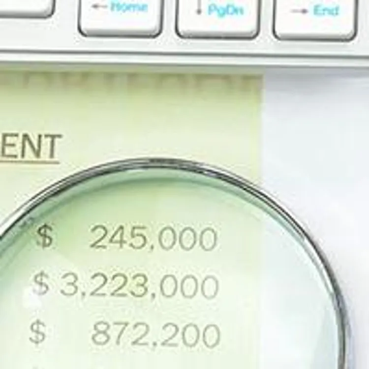 Mortgage Refinance Loan Application Form along with numbers on the side seen through a magnifying glass