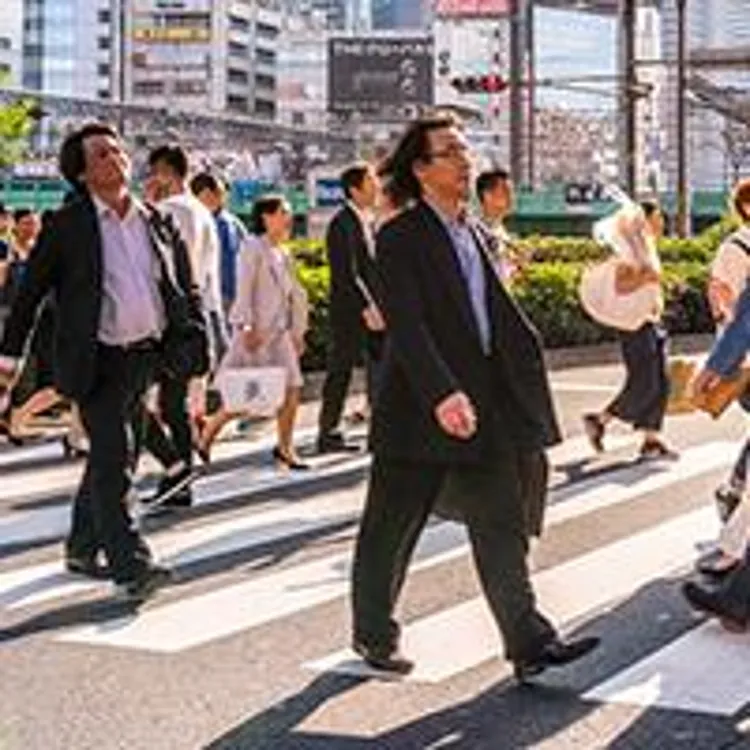 people in the crosswalk of a busy city street