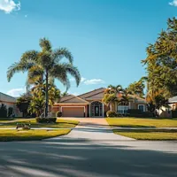 a house with a lawn and palm trees