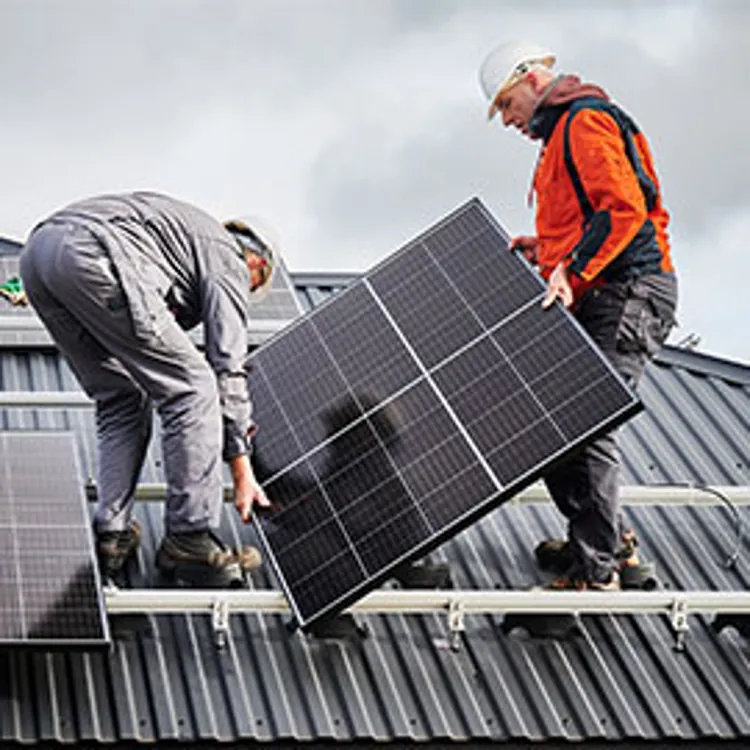 two men installing solar panels on roof