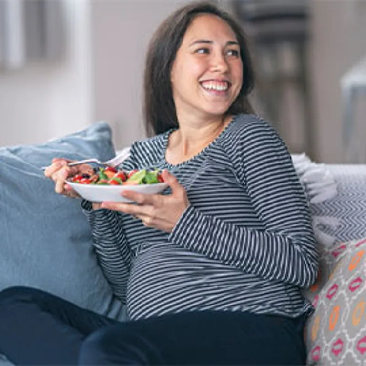 young pregnant woman enjoying a healthy salad meal