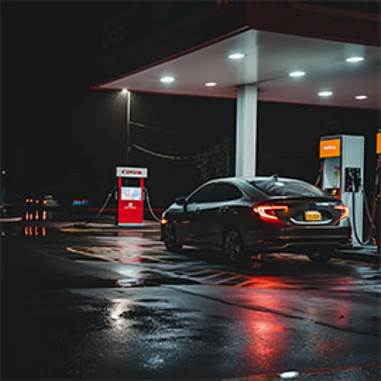 image showing a black car parked and loading gas on a gas station