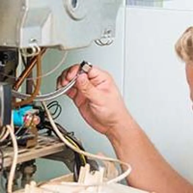hvac technician working on furnace