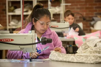 worker behind sewing machine