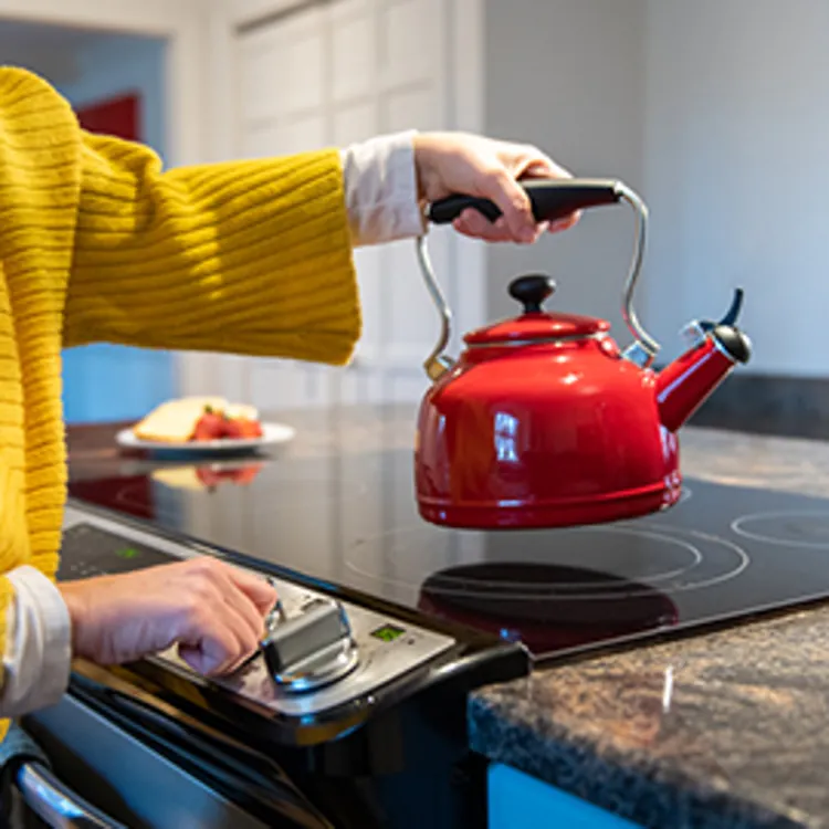 woman making tea on electric stove