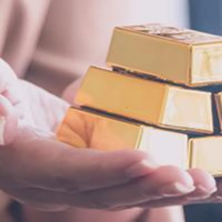 gold bars stacked in womans hands