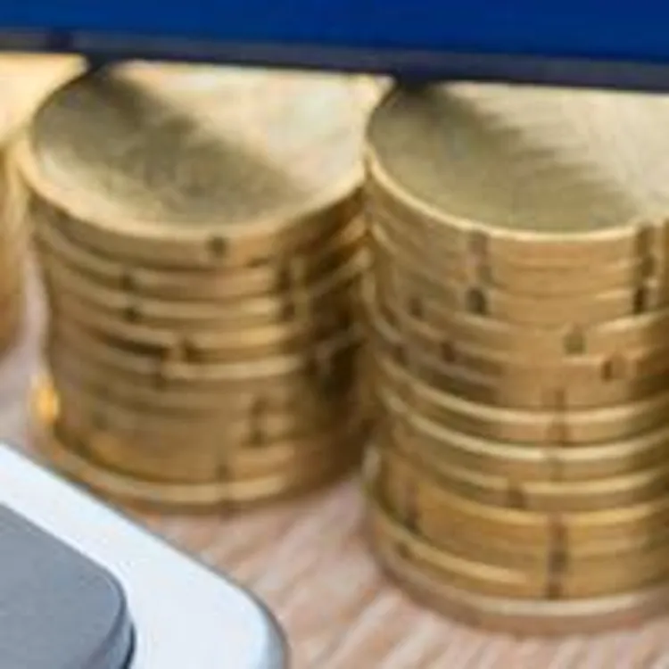 stacks of gold coins with calculator and pencil