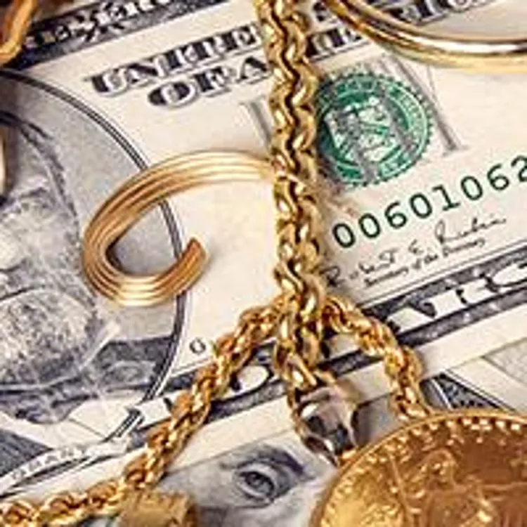 gold and silver coins and accessories laying on money