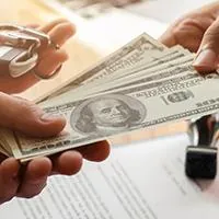 hands passing cash and car keys