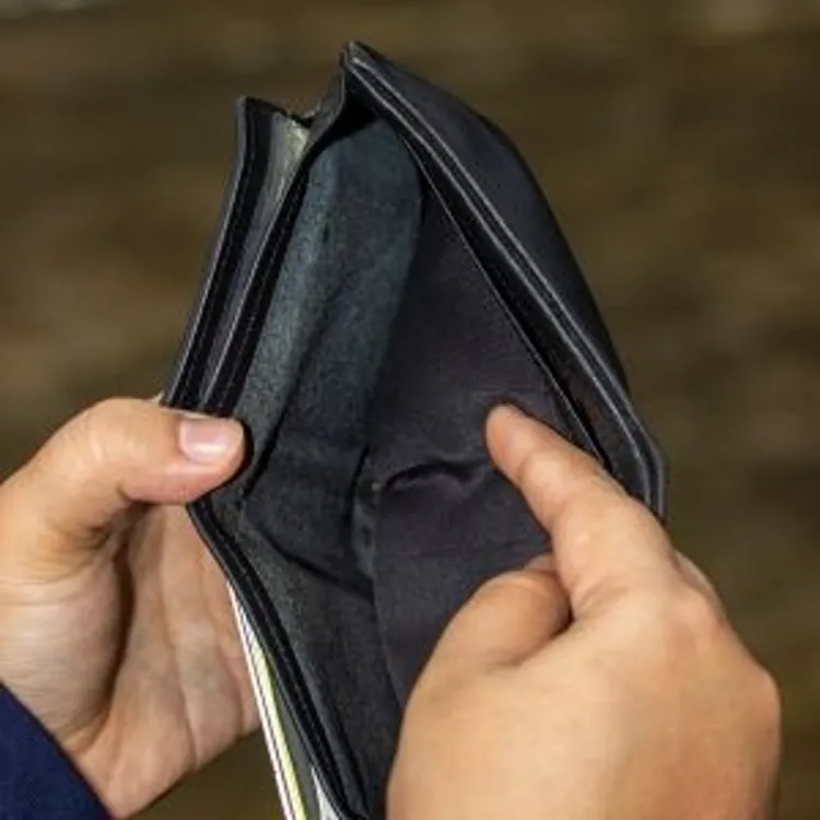 Hands holding an open empty black wallet