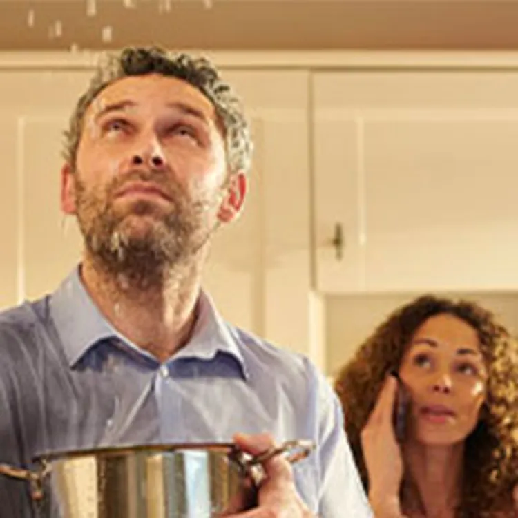 family looking at leaking water from ceiling