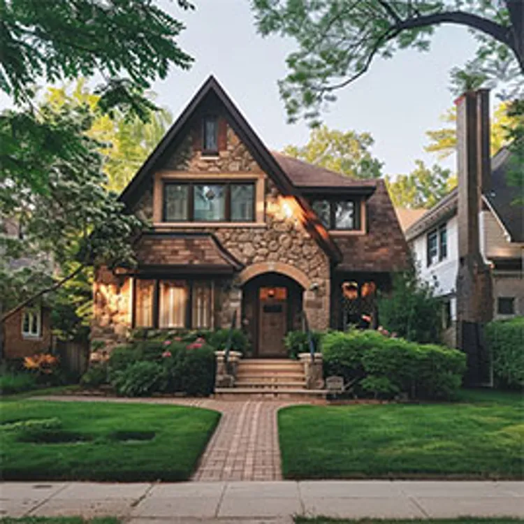home with brick pathway leading to arched front door