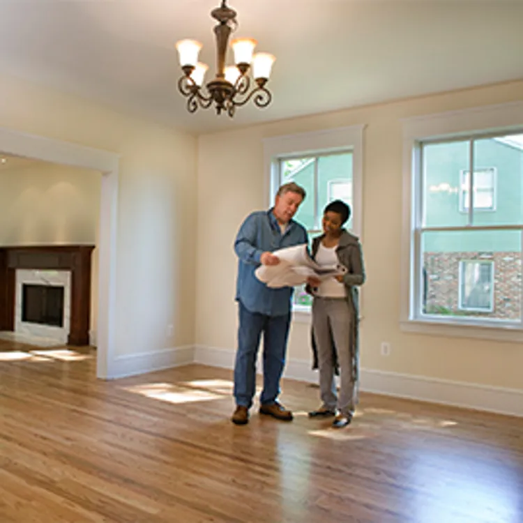 homeowner and home inspector looking over paperwork in empty home