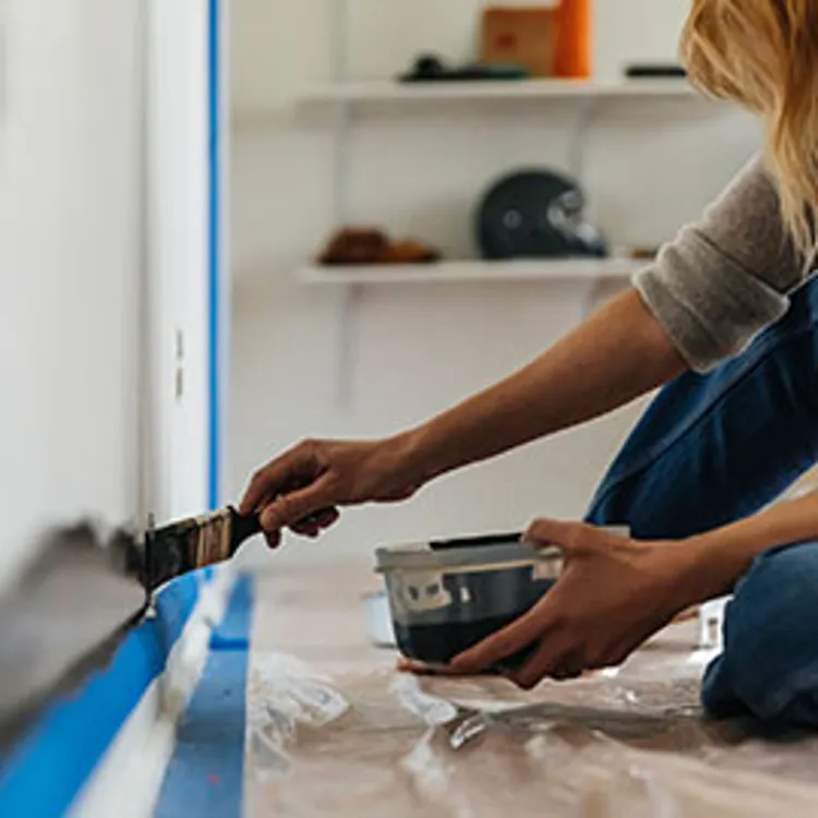 woman applying paint on wall