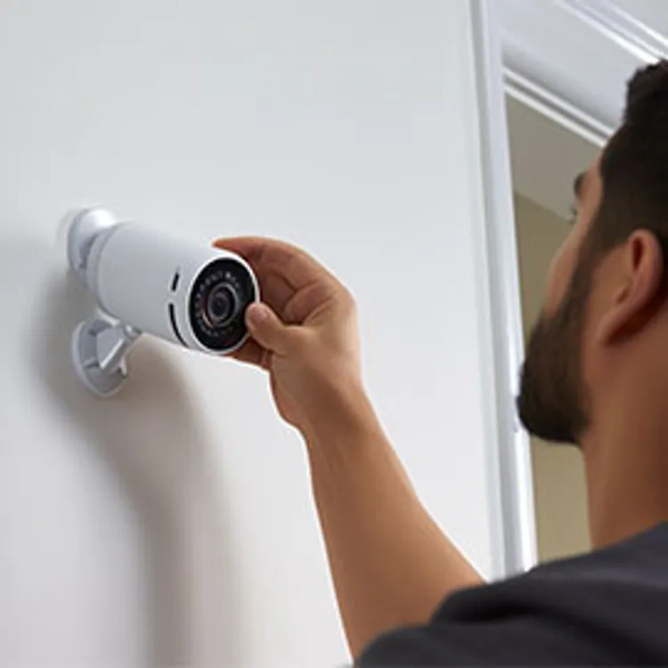 home security technician installing a security camera