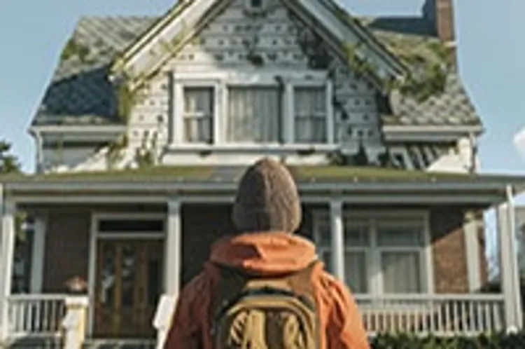 a man with a backpack standing in front of a house