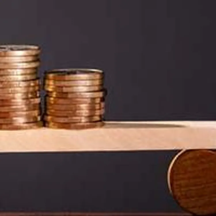 house balanced on scale with coins