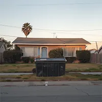 large dumpster on the sidewalk in front of a home
