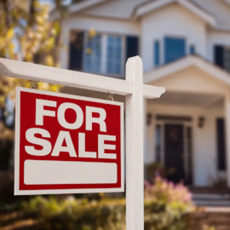 for sale sign in the front yard of a house