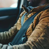 a man wearing seat belt inside a car