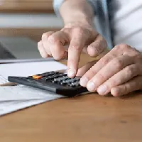 hand using calculator to compute costs