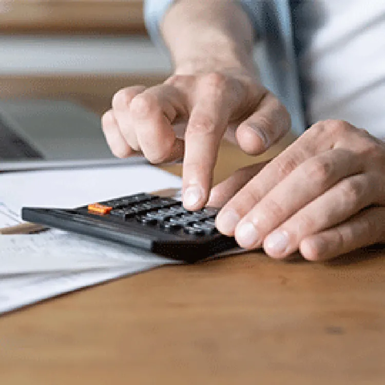 hand using calculator to compute costs