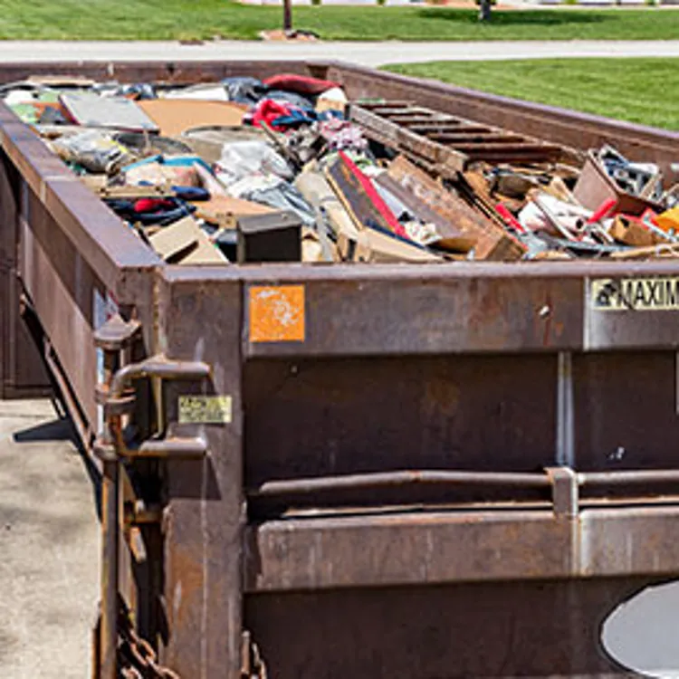 waste dumpster full of household junk
