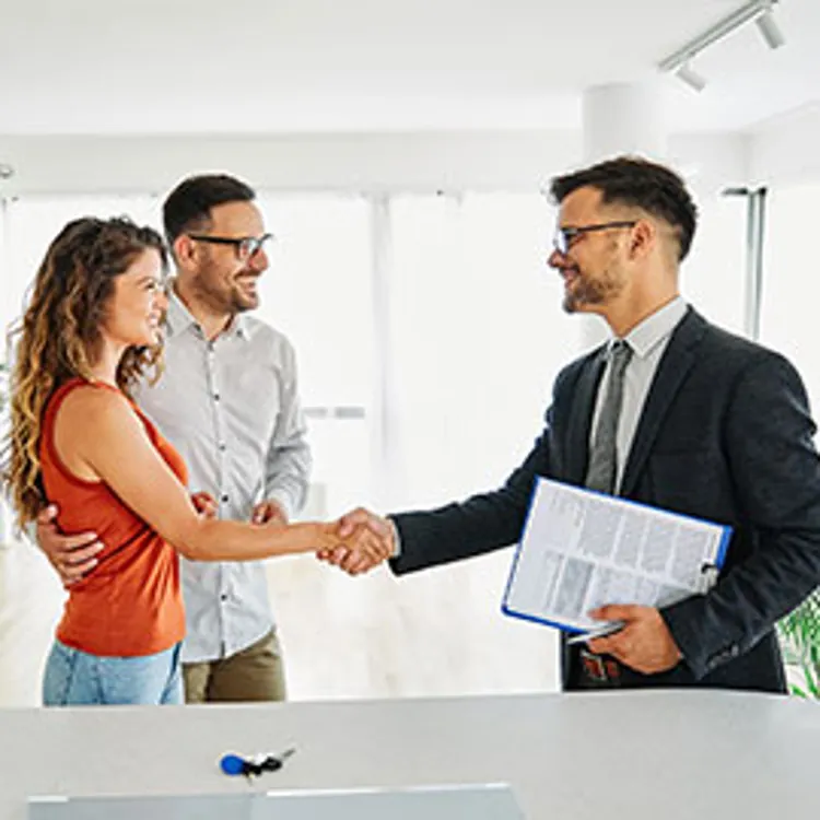 couple shaking hands with realtor
