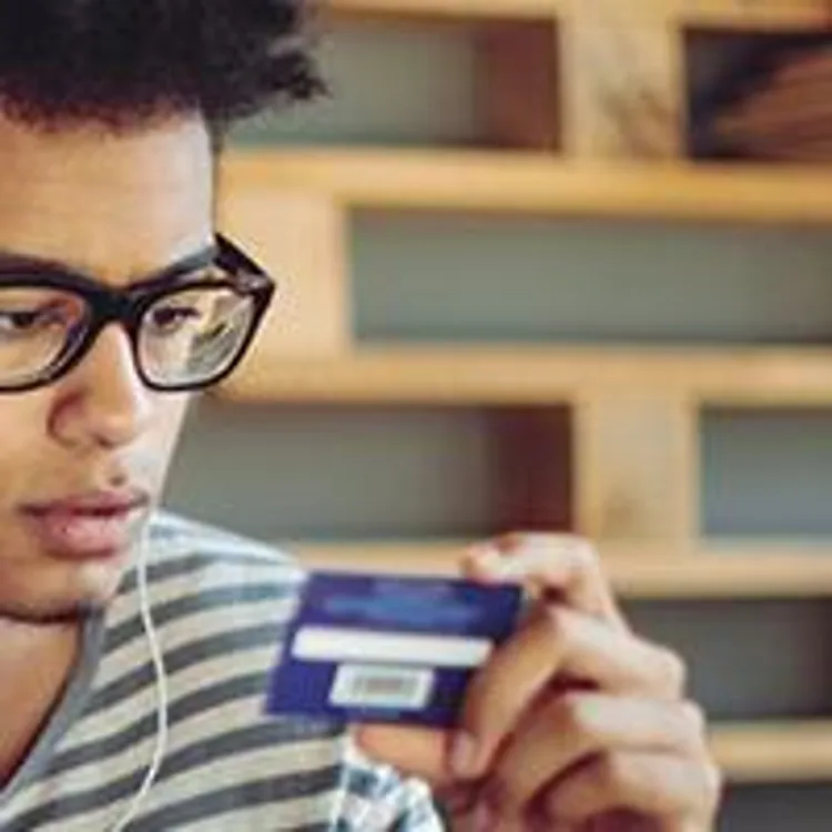 teenager holding and looking at a credit card