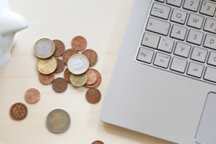 piggy bank with change next to laptop