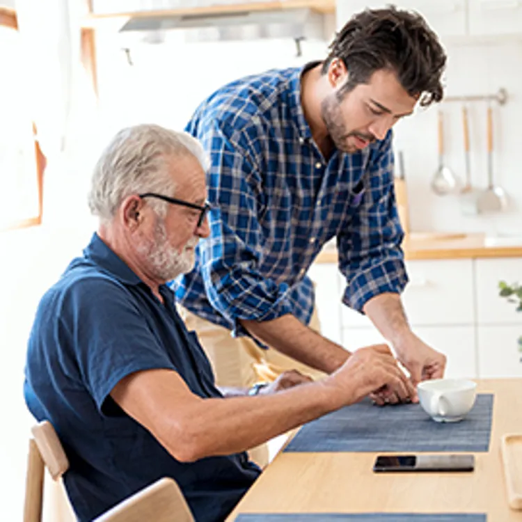 son serving breakfast to elderly father