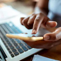 woman using mobile phone and laptop