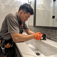 handyman checking a bathroom faucet