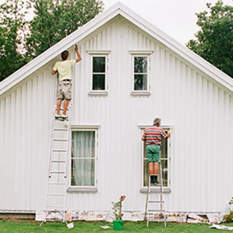 two men painting house exterior