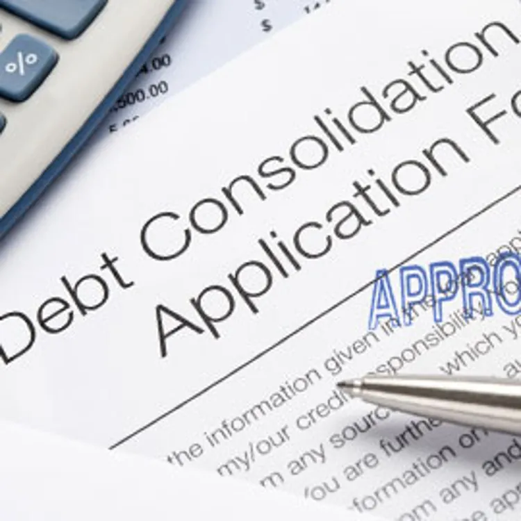 close up of approved debt consolidation loan application form with partial shot of reading glasses