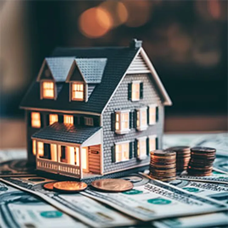 miniature house with lights and a stack of coins next to it