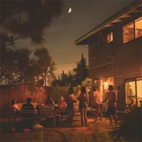 people enjoying a party in the backyard of a home